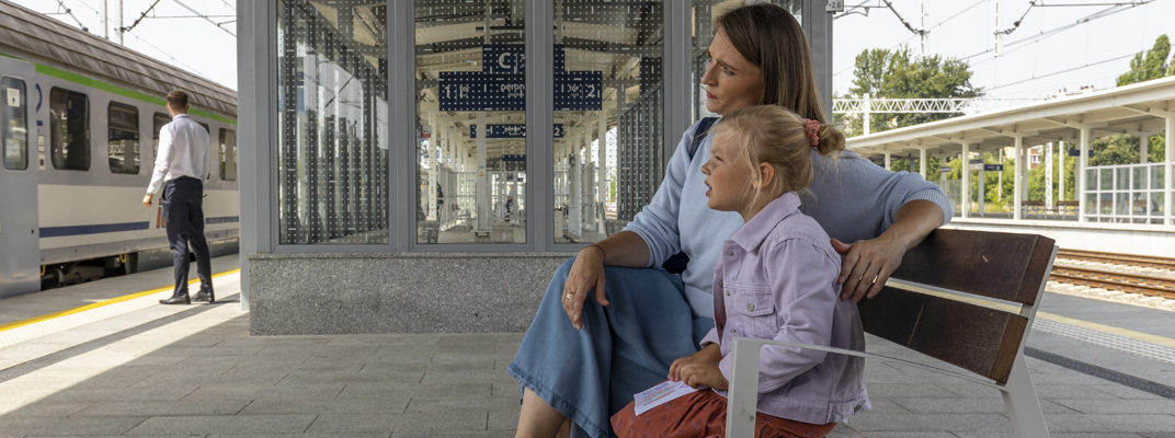 Zdjęcie mamy z dzieckiem czekającej na pociąg